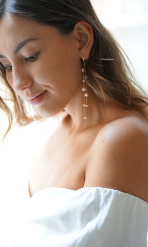 Mariée portant des boucles d'oreilles pendantes à perles naturelles