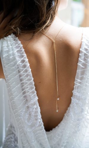collier de dos en or avec une bille réglable et des perles naturelles pour finir le décolletés de dos