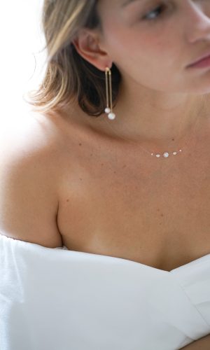Mariée portant un collier de mariée avec fil transparent et cinq perles naturelles